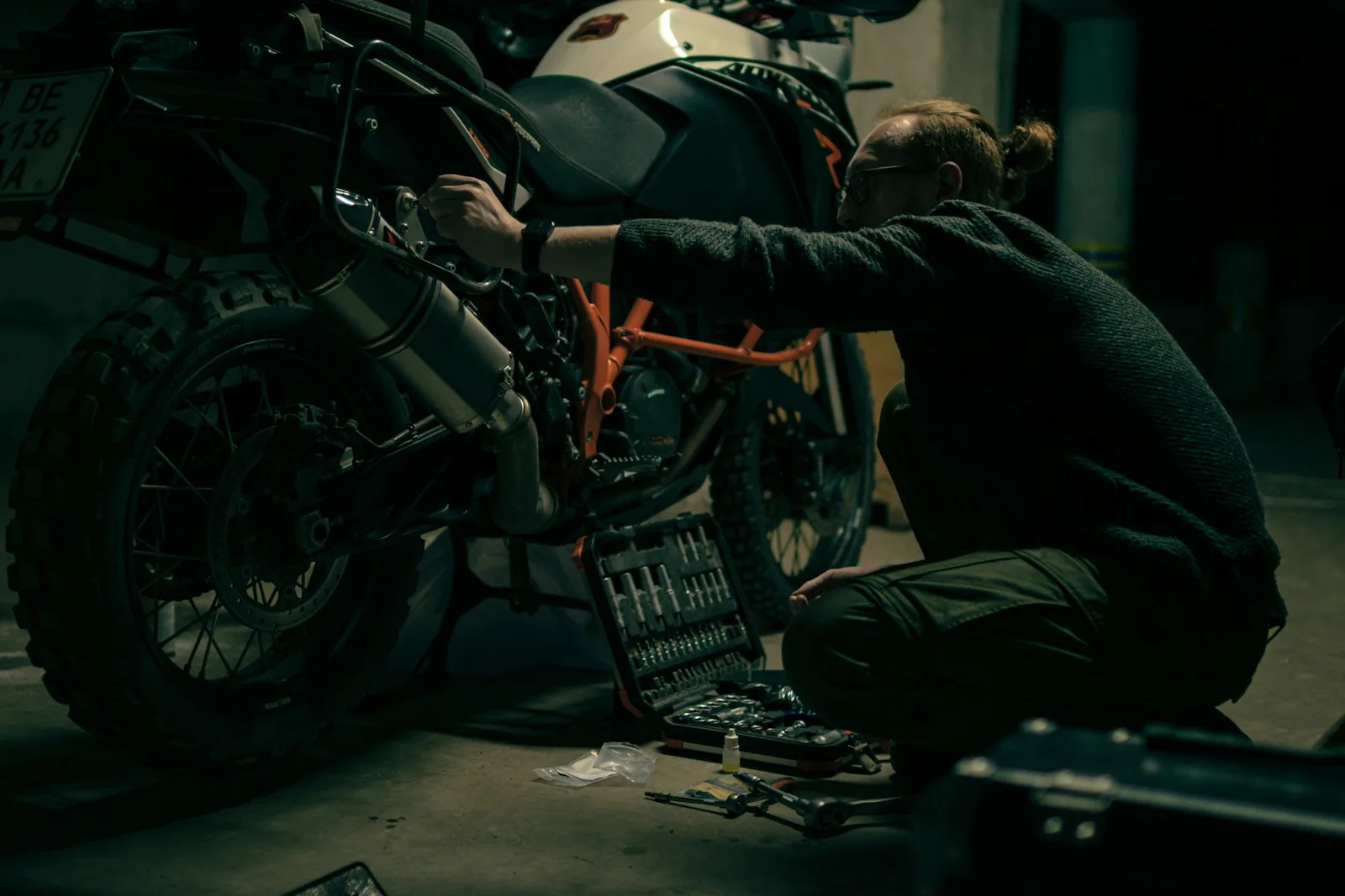 KI-Telefonassistent für Motorradläden – Mechaniker arbeitet an einem Motorrad, während die KI Anrufe annimmt